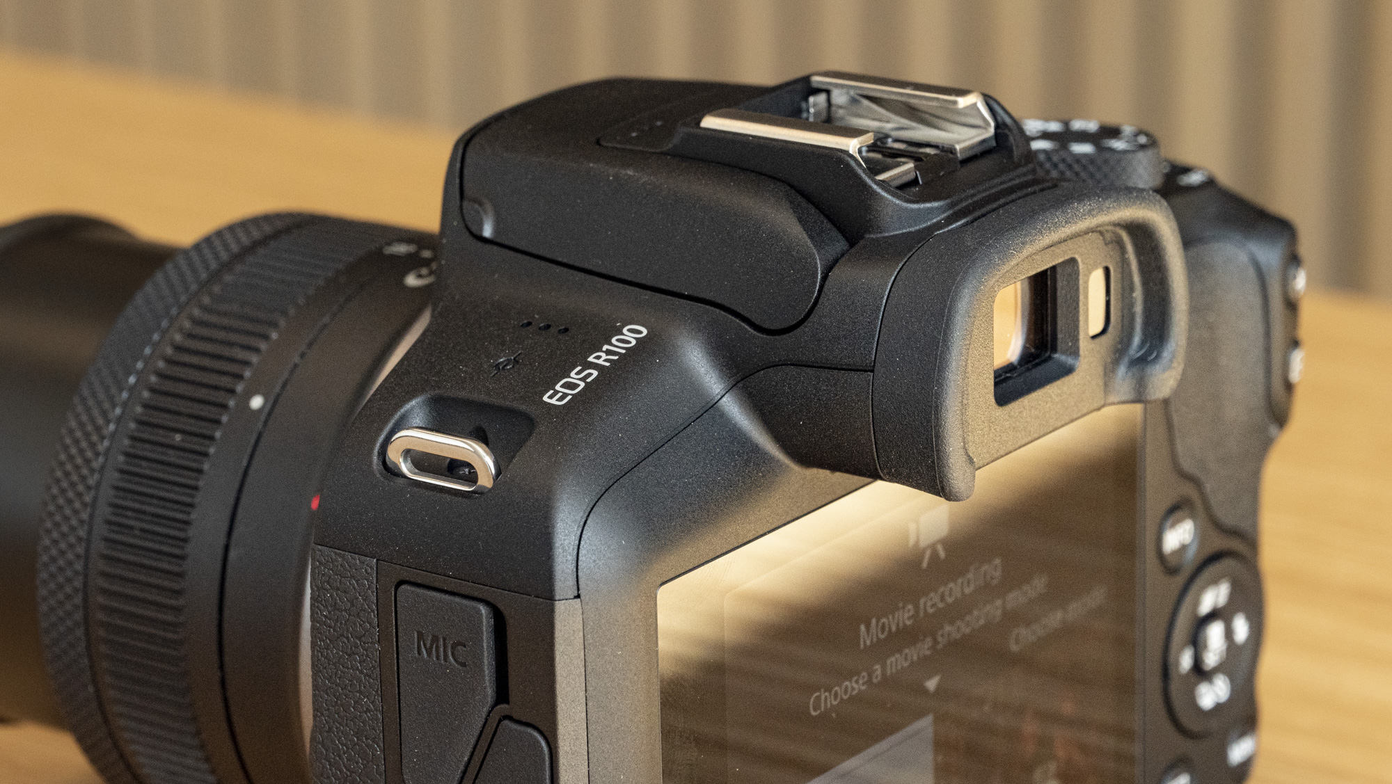 Canon EOS R100 camera on a table closeup of model name
