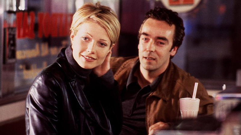 A still from the movie Sliding Doors of Gwyneth Paltrow as Helen Quilley and John Hannah as James Hammerton sitting side by side.