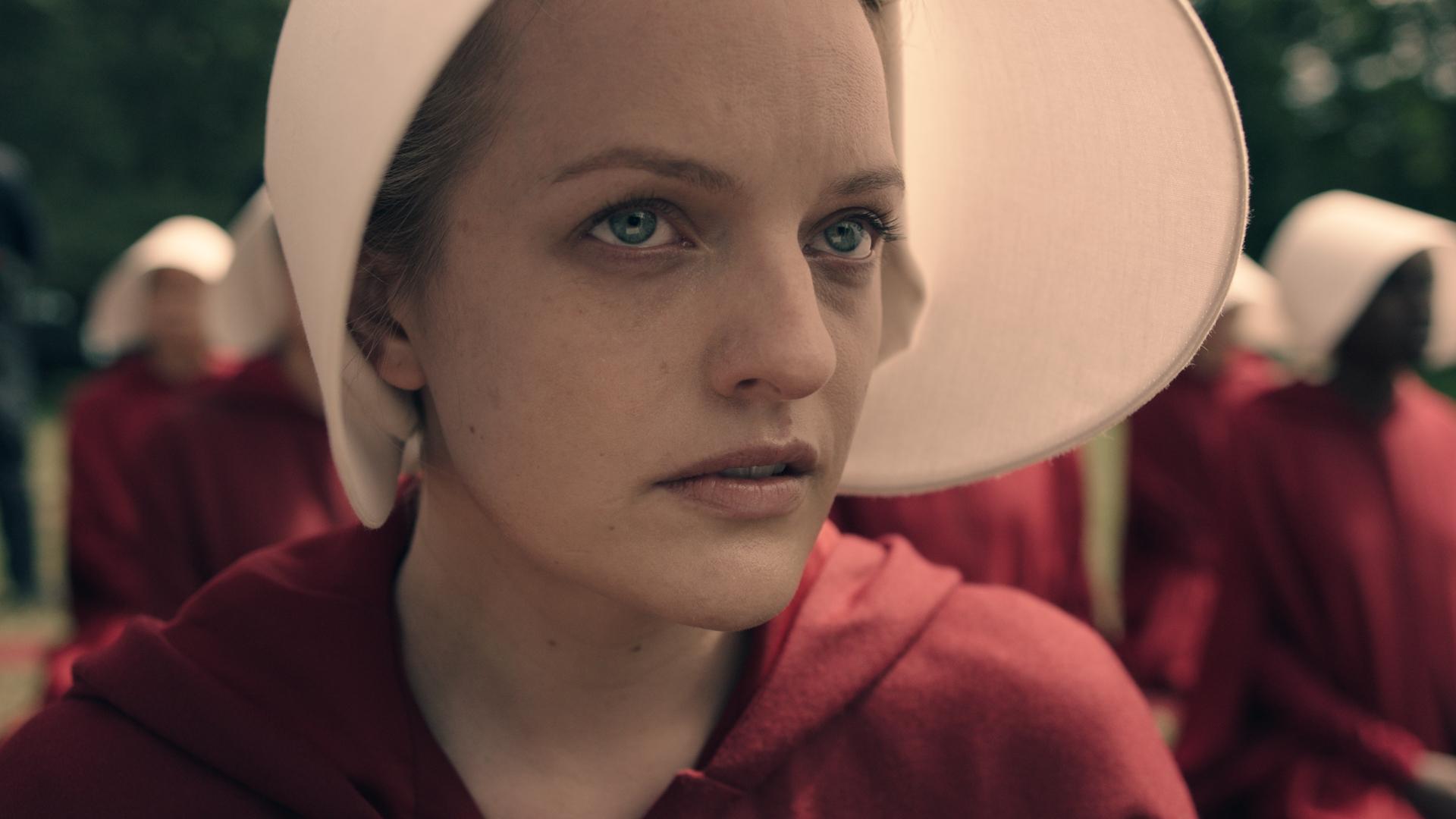 Elisabeth Moss' Offred looks at something off camera in The Handmaid's Tale